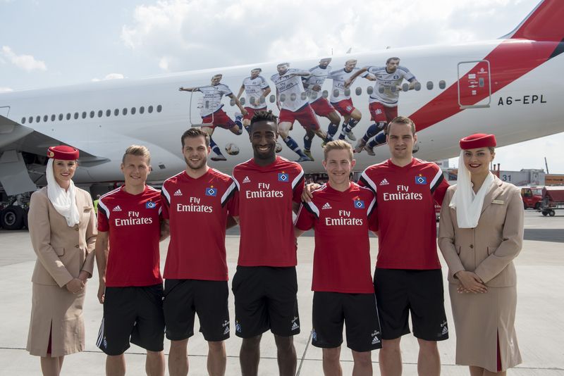 Die HSV-Spieler (von links nach rechts Matthias Ostrzolek, Dennis Diekmeier, Johan Djourou, Lewis Holtby, Pierre-Michel Lasogga) mit Emirates Cabin Crew vor dem in Hamburg vorgestellten HSV-Jet