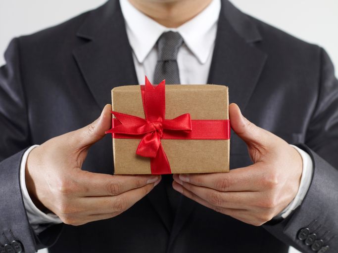 Kleine Geschenke erhalten die Freundschaft- und die Kundenbindung. Businessman holding gift box on white background