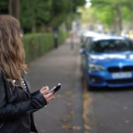 Frau mit Handy an der Strasse
