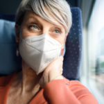 Frau mit FFP2-Maske in der Bahn