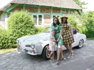 Frauen vor einem Oldtimer