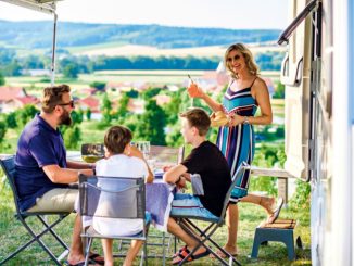 Familie beim Camping beim Frühstück