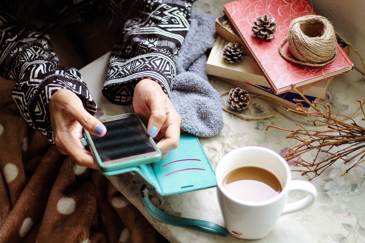 Handy in Benutzung mit Kaffee