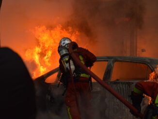 Feuerwehrmann an brennendem Auto