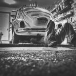 Mann repariert Käfer in der Garage