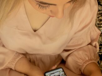 Mädchen checkt Instagram auf dem Handy