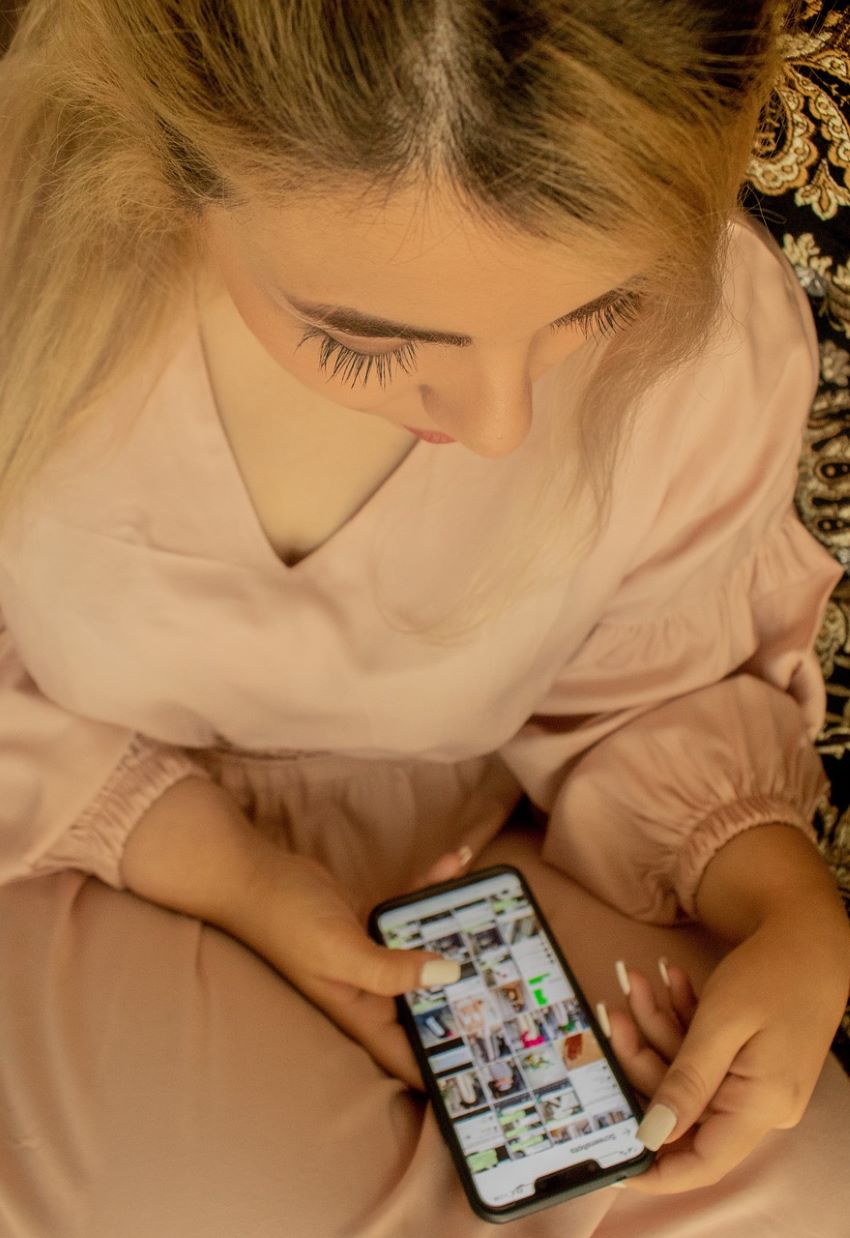 Maedchen-mit-Handy-schaut Instagram | Mädchen checkt Instagram auf dem Handy