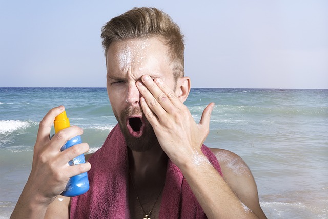 Mann sprueht sich Sonnencreme ins Auge | Mann sprueht sich Sonnencreme ins Auge