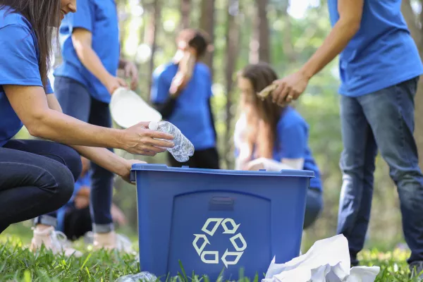 Menschen sammeln Plastikmüll in eine blaue Kiste | Menschen sammeln Plastikmüll in eine blaue Kiste