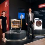 Historische Holzbottichwaschmaschine 'Hera' von 1902 neben dem neuen Spitzenmodell, der W2 Nova Edition