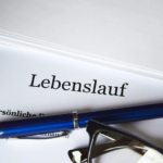 Lebenslauf mit Kugelschreiber und Brille