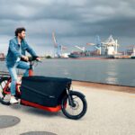 Mann mit Lastenrad an der Elbe vor Hamburger Hafen