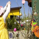 Kind schückt Strauch mit Ostereiern