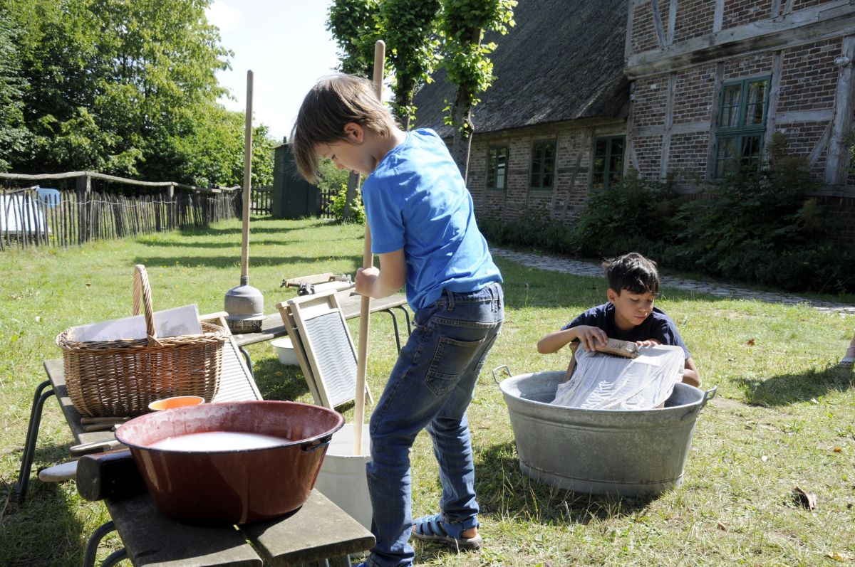 Beim Sommerspaß bäuerliches Leben im letzen Jahrhundert ausprobieren | Kinder probieren beim Sommerspaß bäuerliches Leben im letzten Jahrhundert