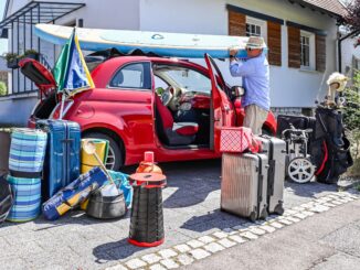 Mann versucht, viel Gepäck in einem Fiat zu verstauen