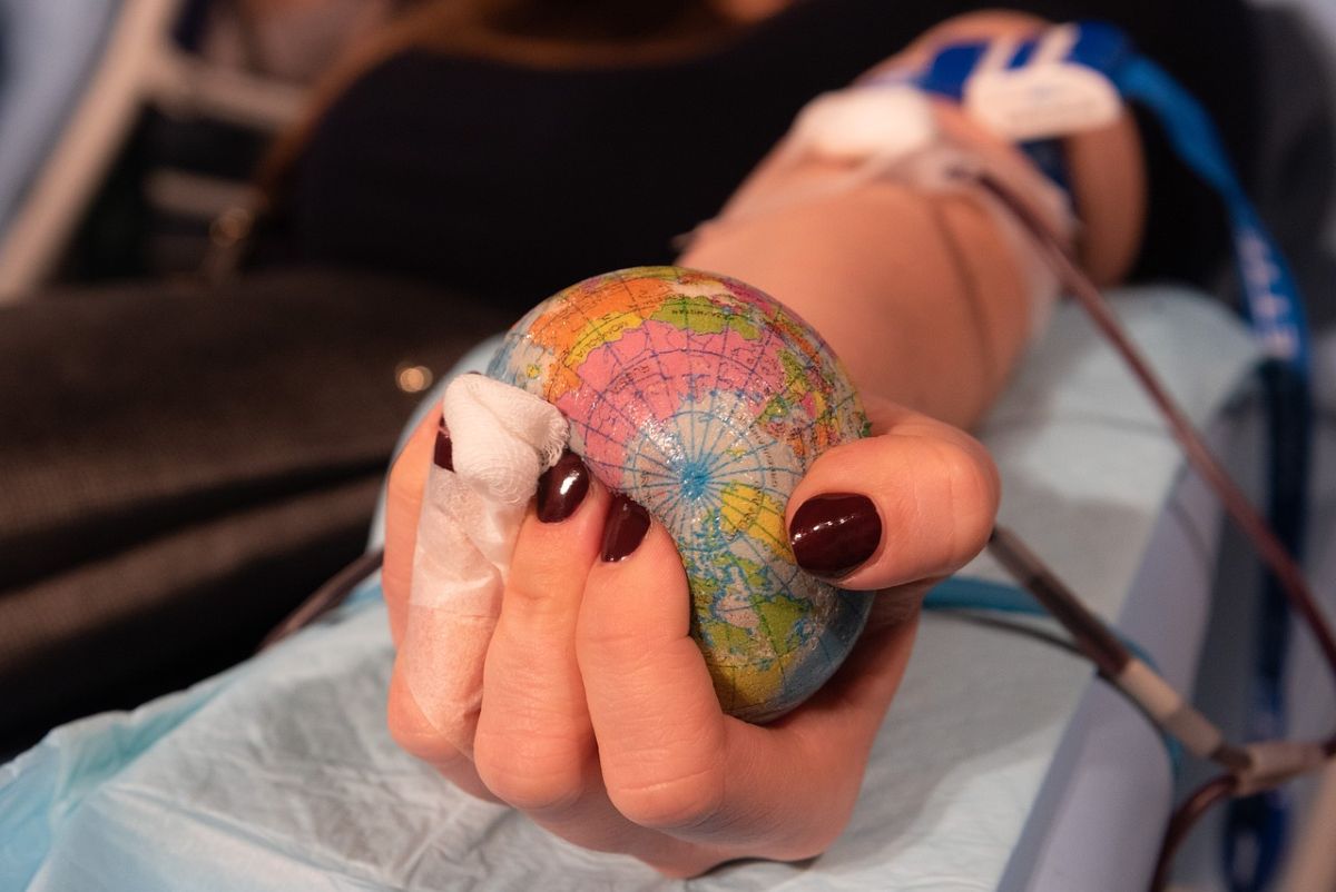 Hand mit Erdball und Transfusionsschläuchen | Hand mit Erdball und Transfusionsschläuchen