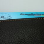 Gesundheitskarte schaut aus einer Lederhülle