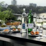 Auf der Terrasse gedeckter Tisch mit Köstlichkeiten, Wein und Wasser