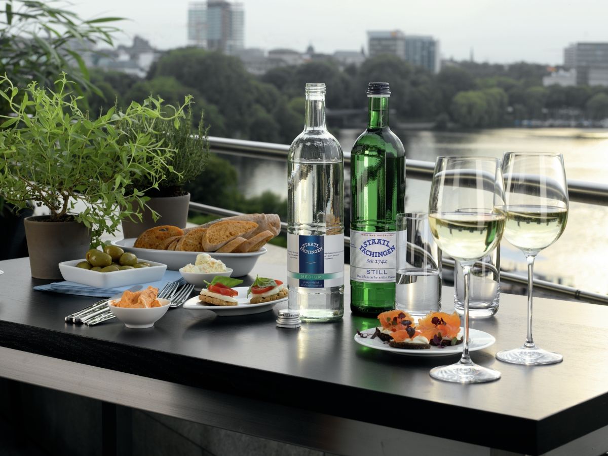 Ein gutes Team - Staatl Fachingen und Wein | hamburg040 Auf der Terrasse gedeckter Tisch mit Köstlichkeiten, Wein und Wasser