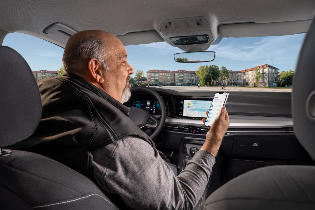 Mann mit Handy in der Hand im Auto