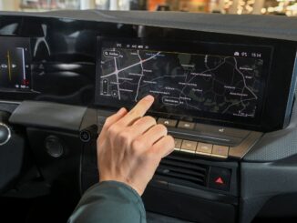 Mann tippt im Auto am Touchscreen