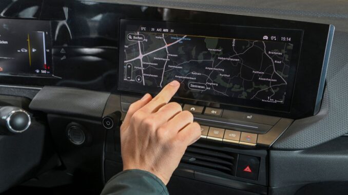 Mann tippt im Auto am Touchscreen