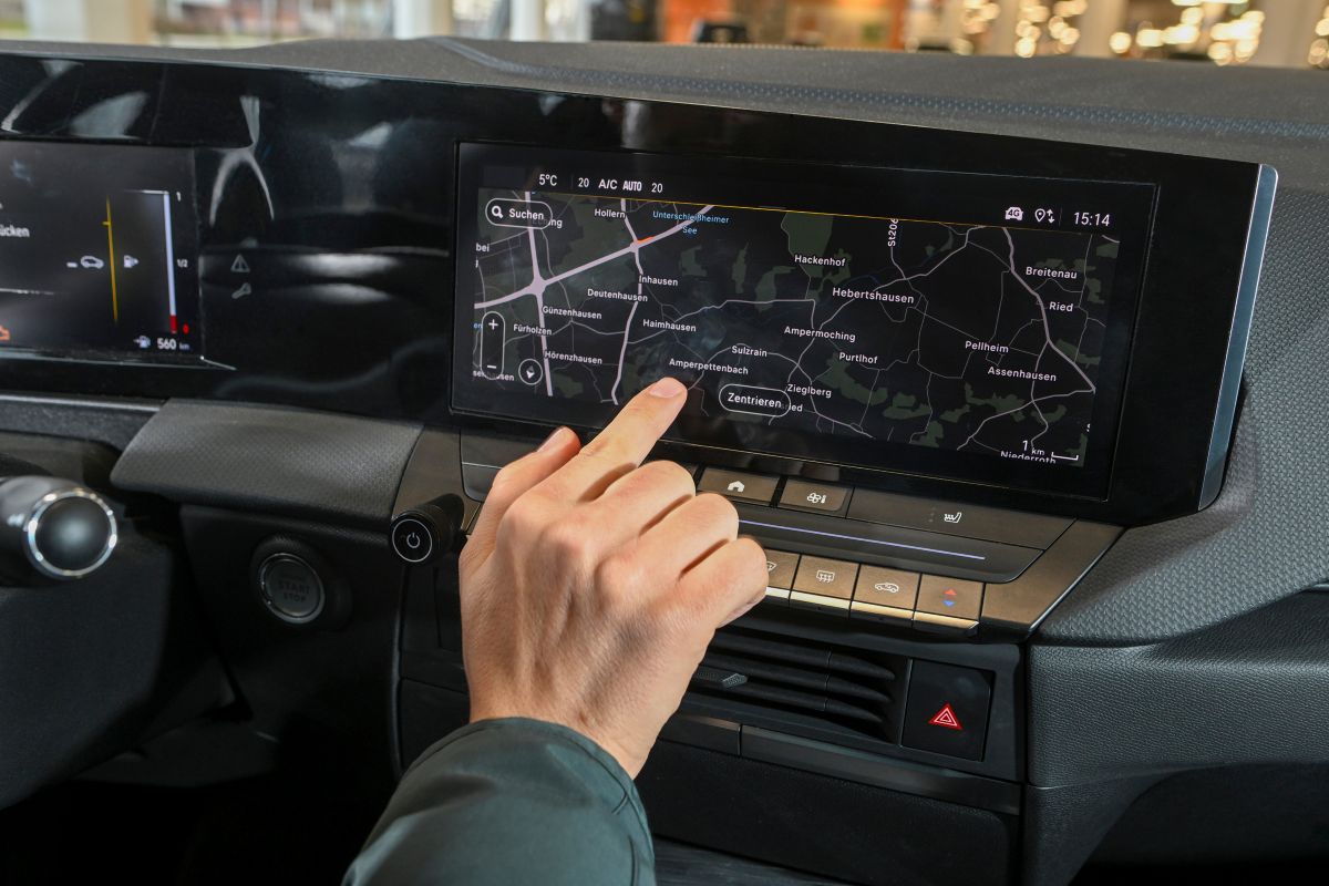 Mann tippt im Auto am Touchscreen