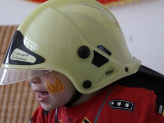 Kind mit Feuerwehrmann-Kostüm