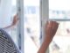 Frau öffnet das Fenster zum Lüften