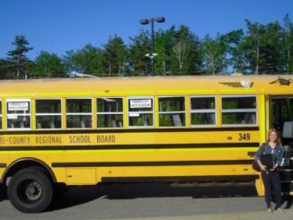 Schülerin vor Schulbus in Kanada