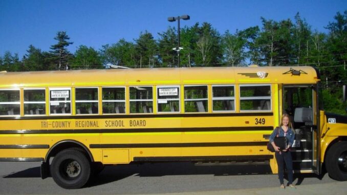 Schülerin vor Schulbus in Kanada