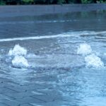 Wasser drückt durch den Kanaldeckel
