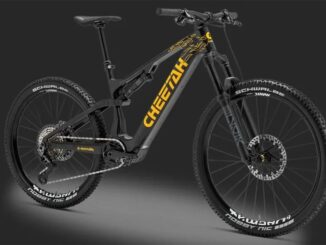 Full-suspension black mountain bike with yellow branding on the downtube, thick knobby tires, on a dark background.
