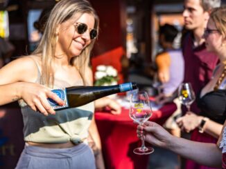 Hostess schenkt Wein ein bei der Rheingauer Weinwoche
