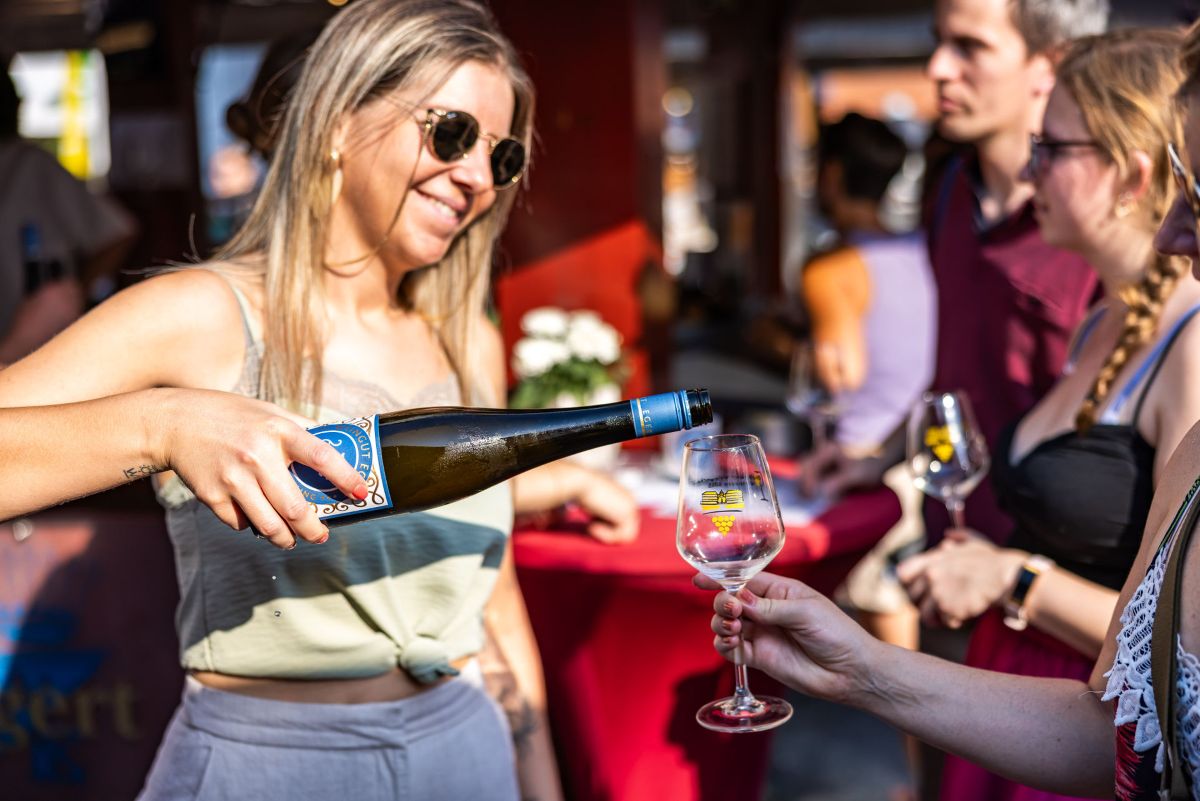 Hostess schenkt Wein ein bei der Rheingauer Weinwoche